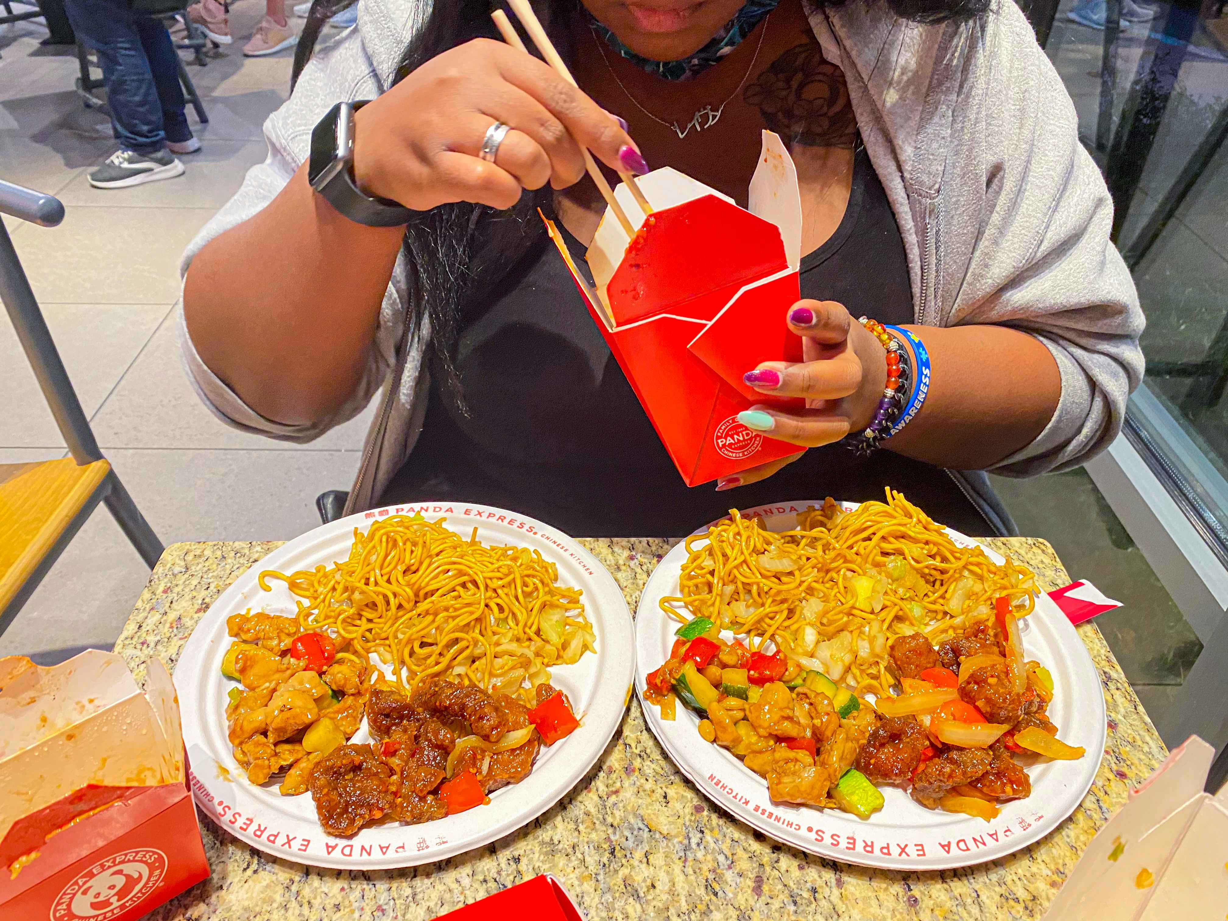 someone splitting a Panda Express bigger place meal into two plates